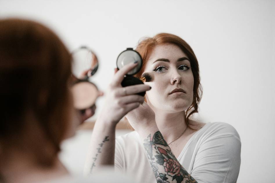 Blogger applying soft natural makeup in sunlight