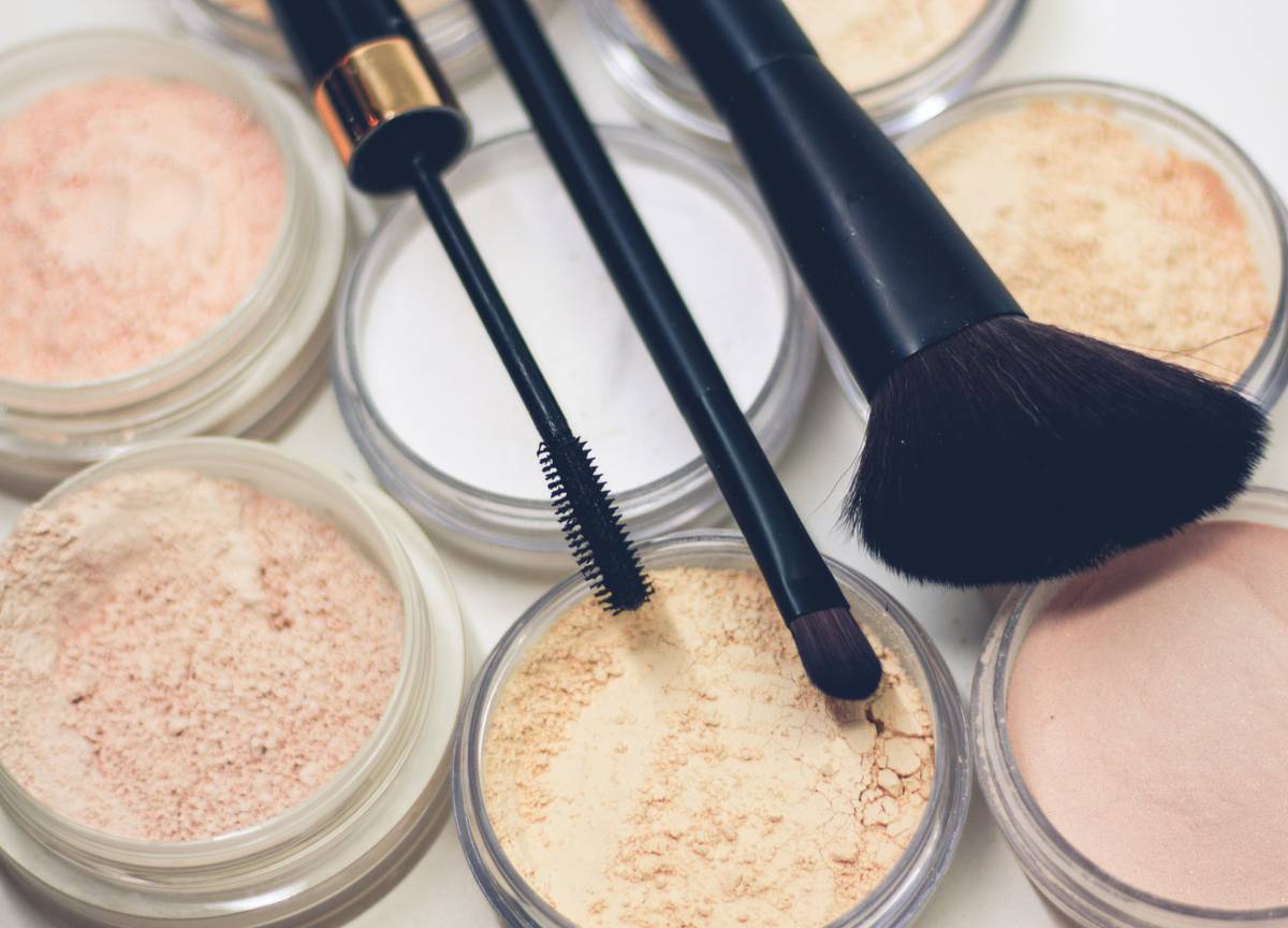 Woman applying natural makeup as part of her eco beauty daily routine using reusable tools and zero-waste products